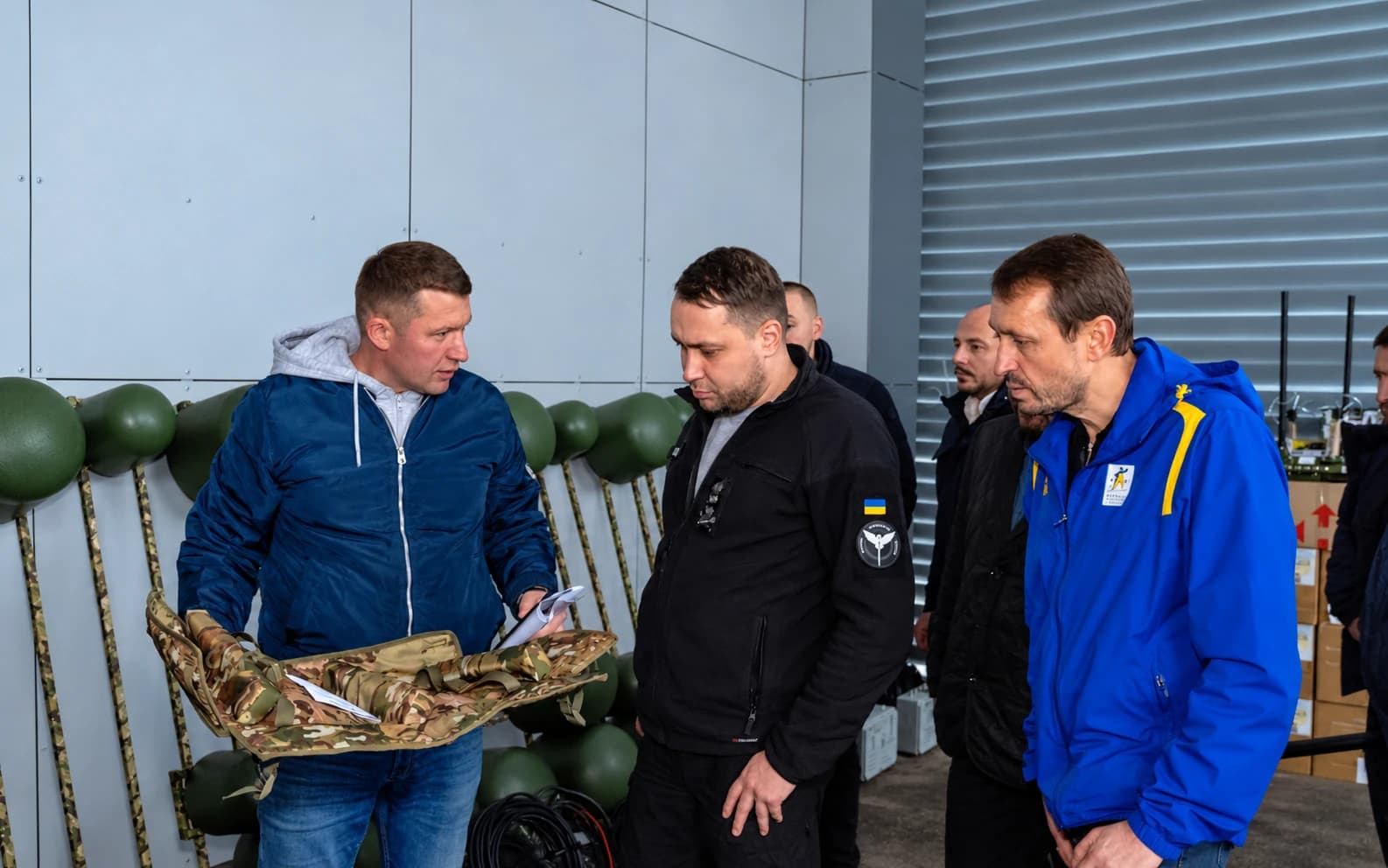 Учасники зустрічі розглядають маскувальний чохол «Луска»